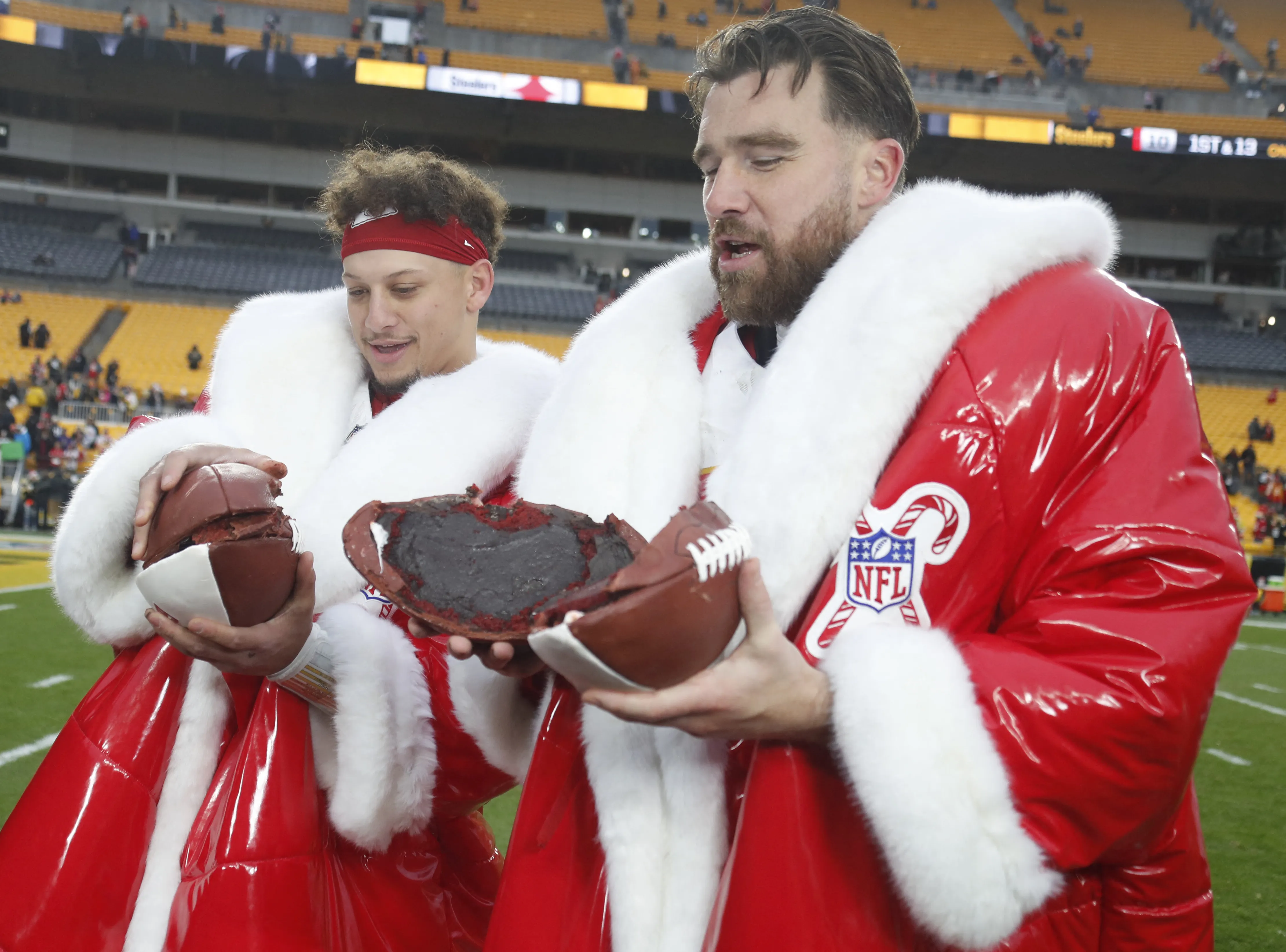 Travis Kelce and Patrick Mahomes opening football cake in 2024.